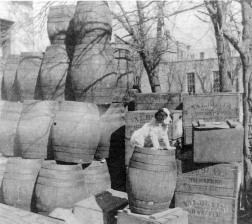 Empty beer kegs and beer cases are stacked behind the saloon located at 226 Missouri Street in this view, circa 1890. Mueller's Hardware store is visible in the background to the right. Photo courtesy Eddie Meinhardt.